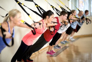 A group of people doing suspension training at the gym.